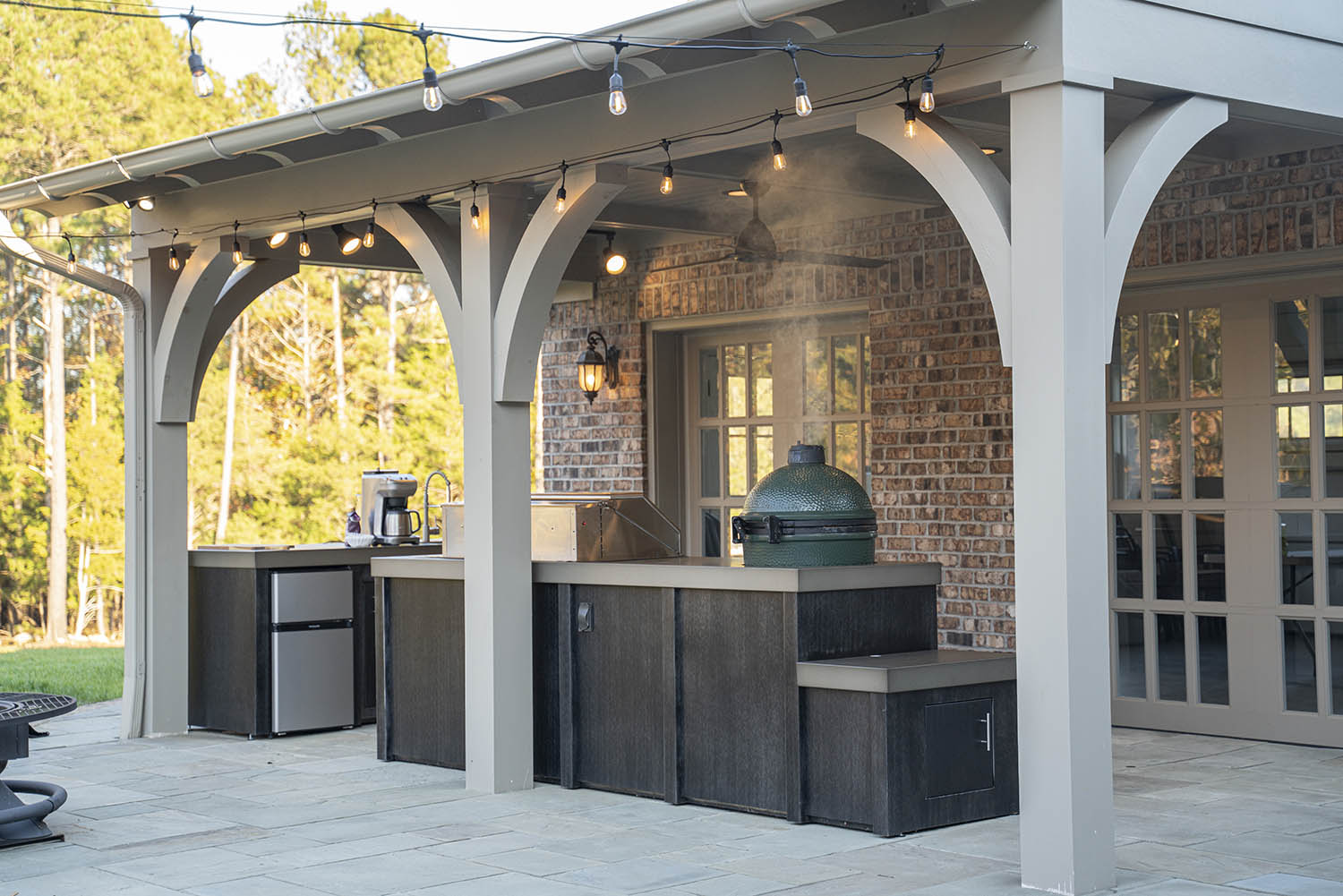 Stoll covered outdoor kitchen with string lighting