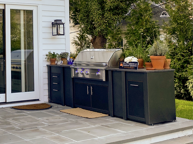 A prefab custom outdoor kitchen from Stoll Industries sits on a patio.
