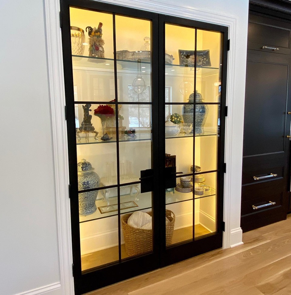 A glass display case holding several vases featuring Stoll Industries' cabinent doors also used in kitchen ideas for kitchen remodels.