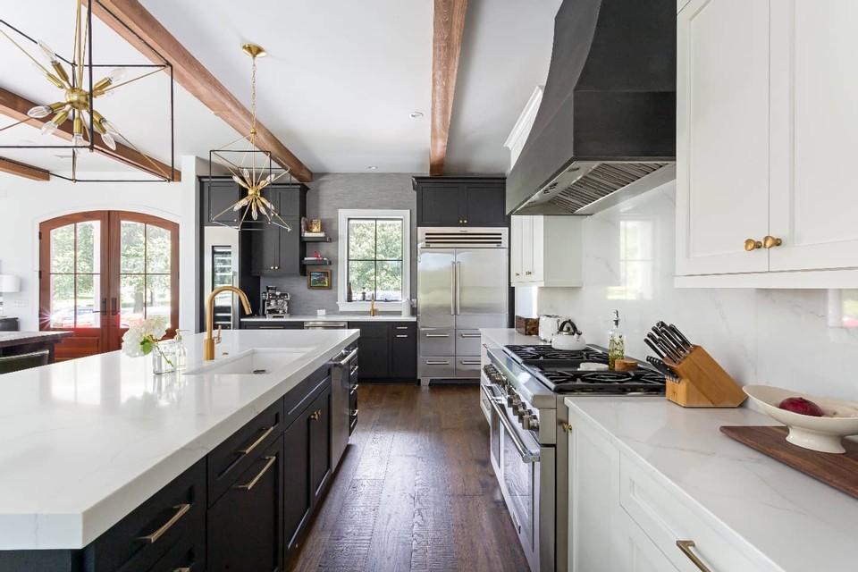 A kitchen by Charleston Home and Design featuring a Stoll Industries Range Hood.