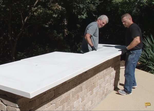 Men building a stone mason outdoor kitchen.