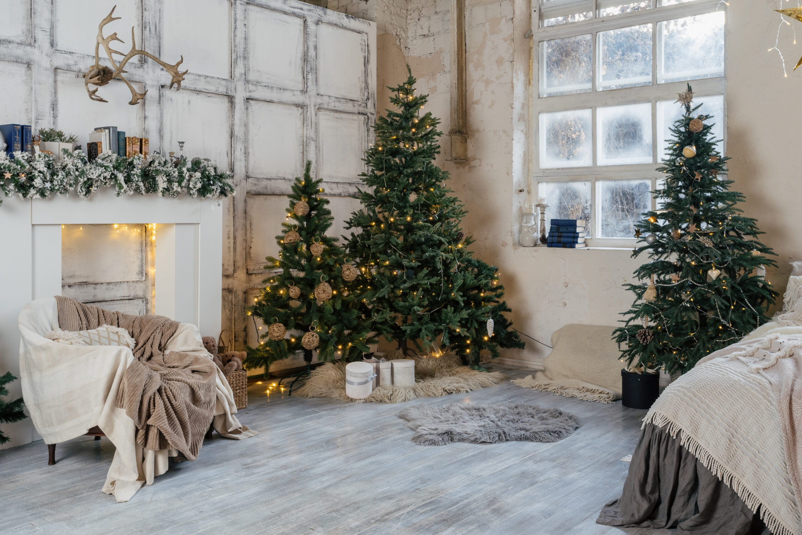Cozy living room with white winter style interior, decorated new year tree, garland lights, comfort armchair, fireplace, present boxes and traditional noel decor at home